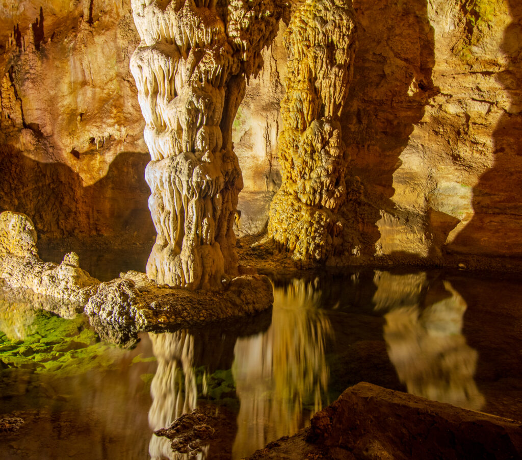 A pool of water reflects the inside of Carlsbad Cavern at Carlsbad Caverns National Park in Carlsbad, NM