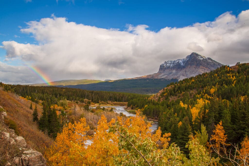 A rainbow looms over Swiftcurrent Creek in the many glacier area of Glacier National Park