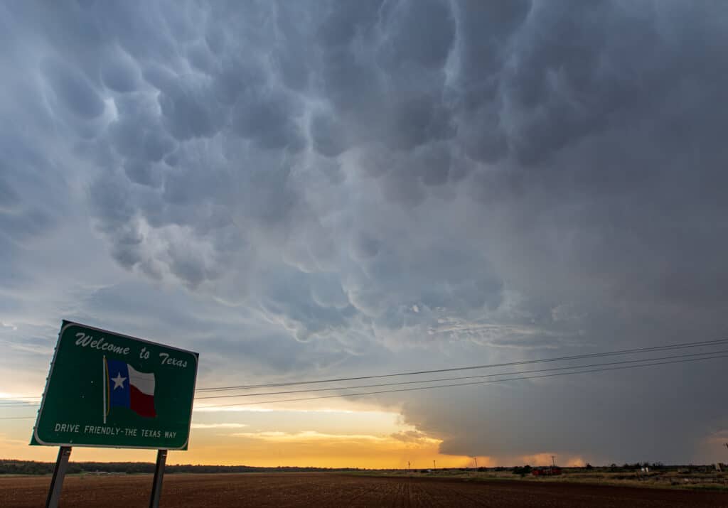 Storm behind a Welcome to Texas sign on the Red River